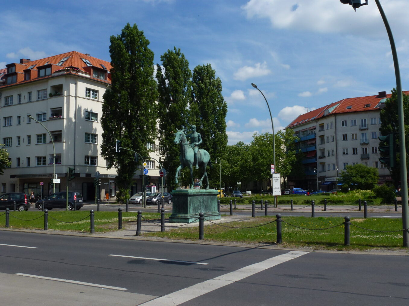 Reiterstatue auf Steubenplatz, umgeben von Wohngebäuden und Bäumen.